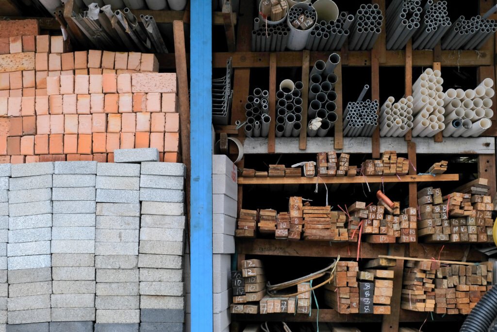Locally sourced construction materials including bricks, wood, and pipes used by sustainable architecture firms in Ghana